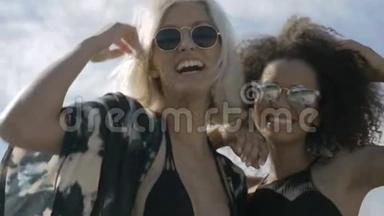两个年轻快乐的时髦女孩戴着太阳镜，在户外玩得很开心。
